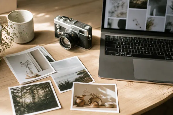 Bureau met foto-prints en een camera